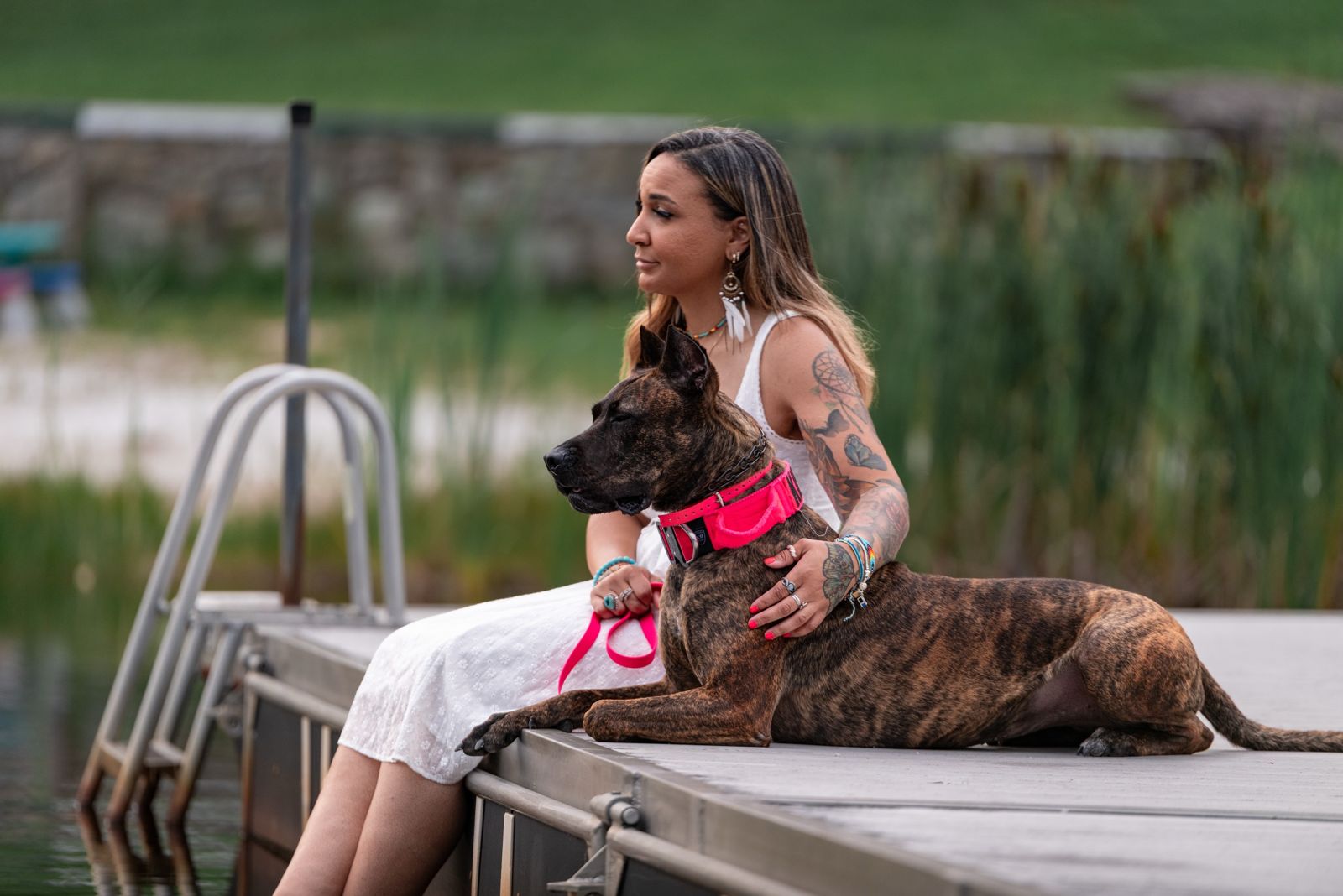 Caity sitting on a dock with her dog Kiera