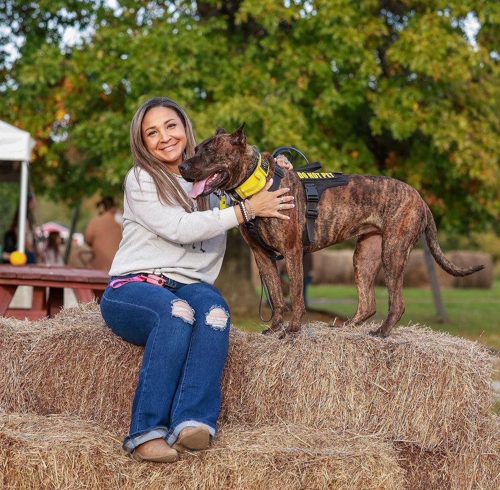 Woman hugging her brindle dog at a fall farm day